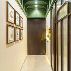 A dose of color can liven up any hallway. The gorgeous green arched ceiling with spotlights draws the eye upward, while a gallery wall of botanical prints adds a touch of nature.