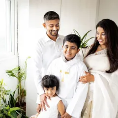 A beautiful family portrait from the Holy Communion celebration. Everyone is dressed in white, creating a bright and cohesive look that marks this special religious milestone.