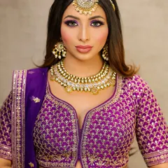 A bold and beautiful look in a purple lehenga. The eyes are the star here, with a dramatic purple smokey effect that is balanced by a neutral lip color.