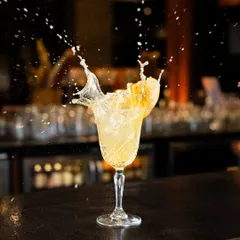 Another dynamic cocktail splash, this time with a yellow cocktail. Capturing the motion and energy like this creates a high-impact visual that's perfect for a bar's promotional content.