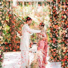 A magical moment as the groom ties the thaali, with a shower of flower petals creating a dreamy atmosphere. We capture the essence of Hindu wedding rituals.