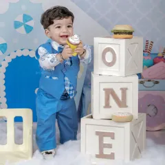 Standing tall next to the 'ONE' blocks, this little boy enjoys a prop cupcake in our sweet shop setup. We use a variety of props to keep children engaged and happy during the shoot.