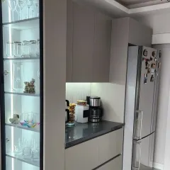 The crockery unit is shown here filled with glassware, demonstrating how the bright, cool-toned LED lighting makes the collection sparkle. This is a perfect example of functional yet beautiful display storage.
