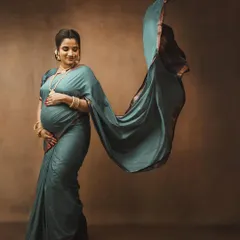 This is one of my favorite shots to create. The flowing saree pallu adds a beautiful, dynamic element to this traditional Maharashtrian maternity portrait, capturing a sense of grace and movement against a classic studio backdrop.
