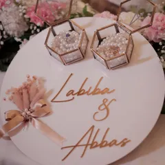 A beautifully crafted custom ring platter for Labiba & Abbas. The design features rose-gold hexagonal boxes on a bed of pearls, showcasing our attention to personalized, luxurious details.