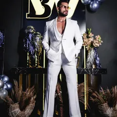 The complete all-white three-piece suit, featuring a unique textured jacket with a shawl lapel. The flared trousers add a touch of retro flair, showcasing our ability to execute bold, fashion-forward designs.
