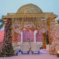 A magnificent golden-domed mandap, adorned with a cascade of pink and white roses. This opulent design is perfect for a grand, royal-themed wedding.