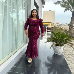 A candid walking shot in a stunning sequined gown. This photo captures a moment of happiness and confidence during an outdoor shoot.