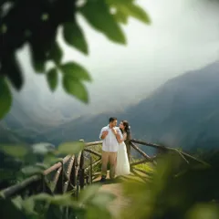 A tender moment on the same mountain viewpoint, framed by foreground leaves to create a sense of intimacy. This technique, part of our 'dreamyframes' style, makes the viewer feel like they are peeking into a private memory.