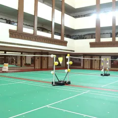 Our courts set up with shuttlecock stands, ready for a session of intense multi-shuttle drills. The high ceilings and professional lighting create an ideal training atmosphere.