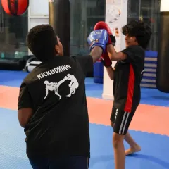 Learning to block and counter. This action shot shows one of our young kickboxing students practicing a defensive block against a jab during a partner drill.