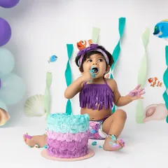 A messy and magical "Under the Sea" themed cake smash! This little mermaid is having the best time exploring her first birthday cake.