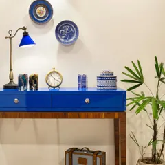 Every home has a piece that steals the show. In Ridge View, it's this deep blue console. A bold nod to the client's love for color, it anchors the space while housing an eclectic mix of books, art, and travel finds.