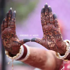 A focused shot on the beautiful dark stain of the bridal mehndi. The contrast between the filled fingertips and the detailed patterns on the palm is a classic bridal look.