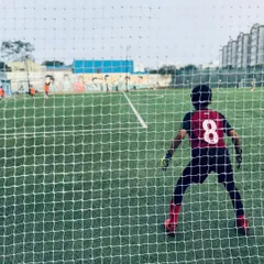A young goalkeeper's perspective from inside the goal, ready for action. The high-quality netting and professional goalposts ensure a safe and authentic playing experience.