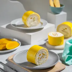 A bright and airy composition of mango Swiss rolls, deconstructed to show the creamy filling and fresh fruit, perfect for a summer menu feature.