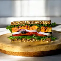Our Homemade Paneer Tikka Sandwich is a classic for a reason. It features soft, marinated paneer tikka, crisp lettuce, onions, and tomatoes on multigrain bread. It’s a taste of home, made healthy.