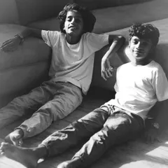 A relaxed portrait of two brothers taking a break from playing. Shooting in your home allows for these comfortable, natural poses that truly reflect their personalities without any forced smiles.