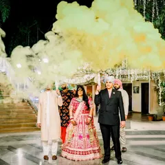 A grand bridal entry with a colorful smoke bomb creating a dramatic effect. This unique and vibrant entrance is a fantastic way to kick off the reception festivities.