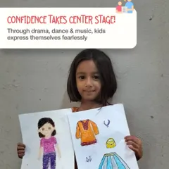 Confidence takes center stage. Through our drama, dance, and music programs, we encourage kids to express themselves fearlessly. This young girl proudly displays her artwork, a perfect example of creative self-expression.