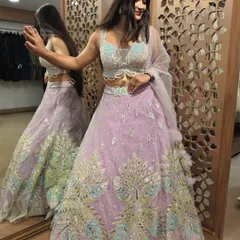 Perfect for a sangeet or a summer wedding, this pre-loved lavender lehenga is pure magic. The intricate peacock-inspired embroidery in pastel shades and the flowy skirt make it a true showstopper.