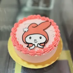 A cute character cake featuring an edible print of My Melody, surrounded by pink buttercream piping.