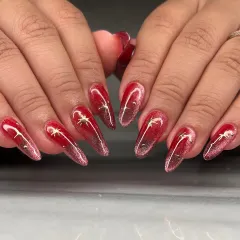 A fiery red cat-eye effect on long coffin nails. I added delicate gold star charms to this set for a touch of celestial magic against the deep, shimmering base.