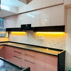 A vibrant U-shaped kitchen showcasing a stylish pairing of blush pink and glossy white cabinets. The design is complemented by a geometric tile backsplash, a sleek black granite countertop, and functional under-cabinet lighting.