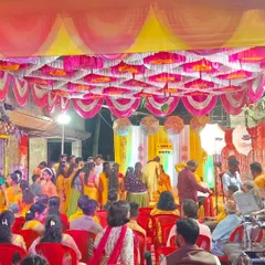 A full view of a lively Haldi ceremony in progress. You can see the colorful pandal ceiling, the stage, and the guests enjoying the function. I can manage events of all sizes.