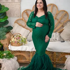 Elegance in emerald. This solo portrait showcases a stunning green lace mermaid gown, with the mother's joyful expression capturing the happiness of this special time. The textures of the gown and the rustic backdrop create a rich, artistic feel.