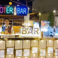 A clear view of one of our popular 'Shooter Bar' setups, featuring a custom neon sign and a well-lit bar front that attracts guests.
