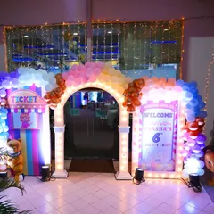 Come one, come all! The grand entrance to a pastel circus carnival party, featuring a ticket booth, a welcome sign, and a colorful balloon arch to transport guests to a world of fun.