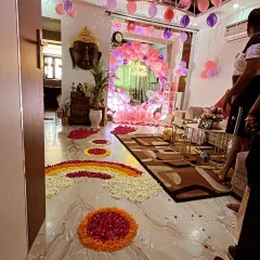 A wide-angle view of the 'Welcome Baby' home decoration, showing the flower petal pathway leading to the main setup in the living room.