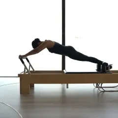 The plank on the Reformer is a powerful exercise for building total body strength. It requires immense core control and stability, a cornerstone of the Classical Pilates method.