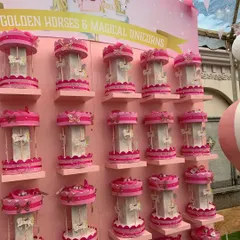 A closer look at the wall of 'Golden Horses & Magical Unicorns' party favors. The consistent pink and white color scheme and delicate details created a stunning visual display.