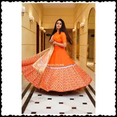 Celebrity Chaitra Vasudevan twirling in a vibrant orange lehenga I designed. The skirt, made from rich Benarasi brocade, has a beautiful flare, making it perfect for festive celebrations.