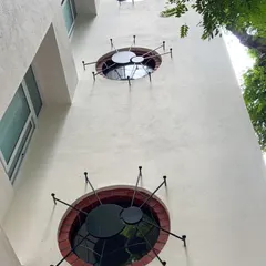 A playful detail on an exterior wall, featuring circular windows with custom metalwork resembling a "spider on the wall". This is an example of how I like to add artistic and unexpected elements to my designs.