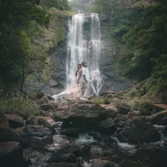 A wide-angle shot that captures the grand scale of the waterfall, with the couple at the heart of the landscape. This showcases our ability to blend epic scenery with intimate moments.