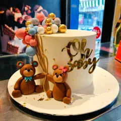 A classic "Oh Baby" cake, perfect for a baby shower. This elegant design features two cute teddy bears holding a bouquet of balloons.
