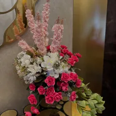 This home wedding decor features a stunning floral installation that flows from a console table and frames a doorway, using a beautiful ombre effect with pink, orange, and white flowers.