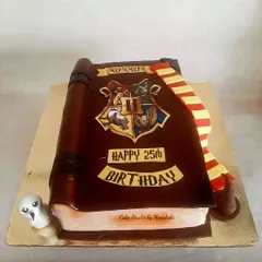 A carved cake designed to look like a magical Harry Potter book. I love how this turned out, complete with the Hogwarts crest and a Gryffindor scarf.
