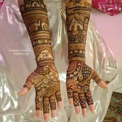 A full bridal mehndi design fit for a queen. This intricate artwork features traditional motifs like elephants and palace architecture, covering the arms from fingers to elbow for a truly royal wedding look.