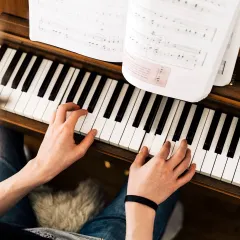 This image captures a student deeply focused on their sheet music while playing the piano. I place a strong emphasis on music literacy, ensuring you can confidently read and interpret musical scores as part of your training.