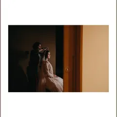 A "behind the scenes" shot of the bride getting her hair and makeup done. This image captures the quiet transformation and the team of artists who help create the final look.