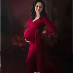 A side profile is a wonderful way to showcase the baby bump. This mom-to-be looks so serene and beautiful in this deep red dress, lost in a happy thought.