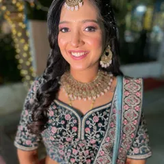 A beautiful reception look. The bride is glowing in a dark green and blue embroidered lehenga with soft pink eye makeup.