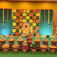 A wide shot of a half-saree function showing the extensive seer plate arrangement in the foreground. I can handle both small and large scale displays.