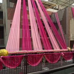 Elegant pink-themed draping for a home's balcony and exterior. This design uses shades of pink fabric and a floral border for a sophisticated look.