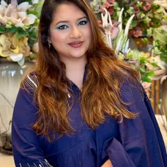 A full view of the client, her bold eye makeup complementing her simple, chic outfit.