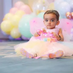 Dressed as a little fairy, this baby girl looks right at the camera. Themed photoshoots allow us to capture a sense of wonder and play, complete with wings and a tiara.